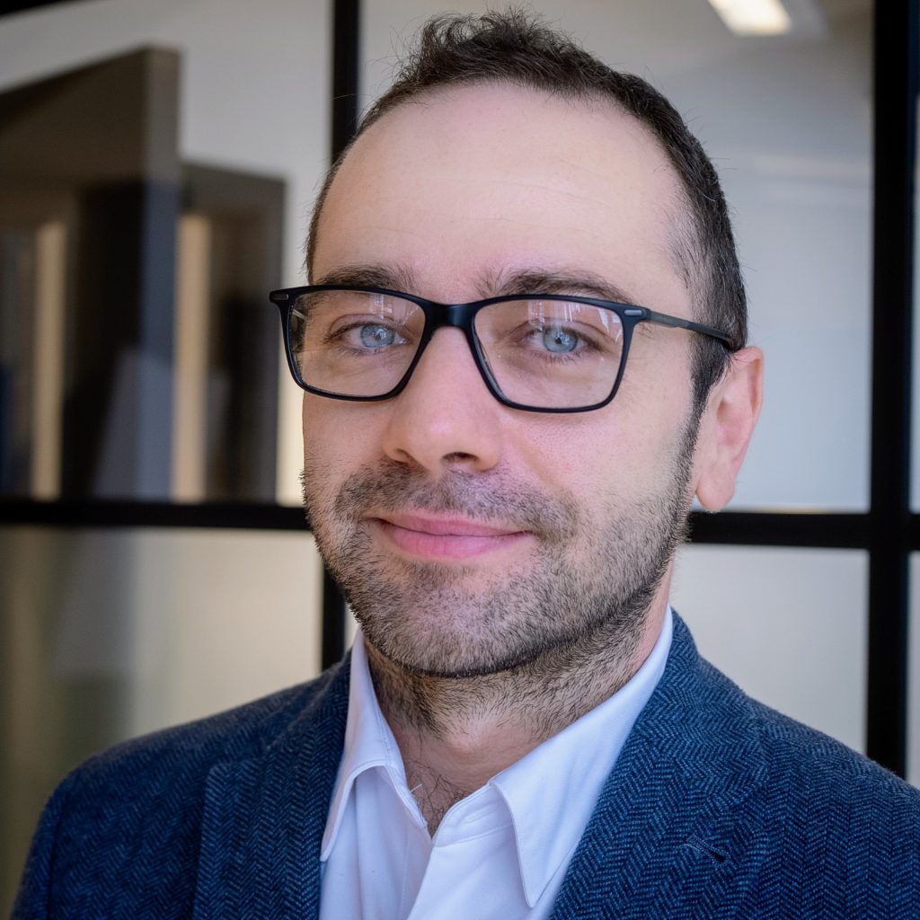Andrew Boxall, founder and managing director of WeChange.AI, brown haired, balding white male with glasses, blue eyes and beard, white shirt and blue blazer.